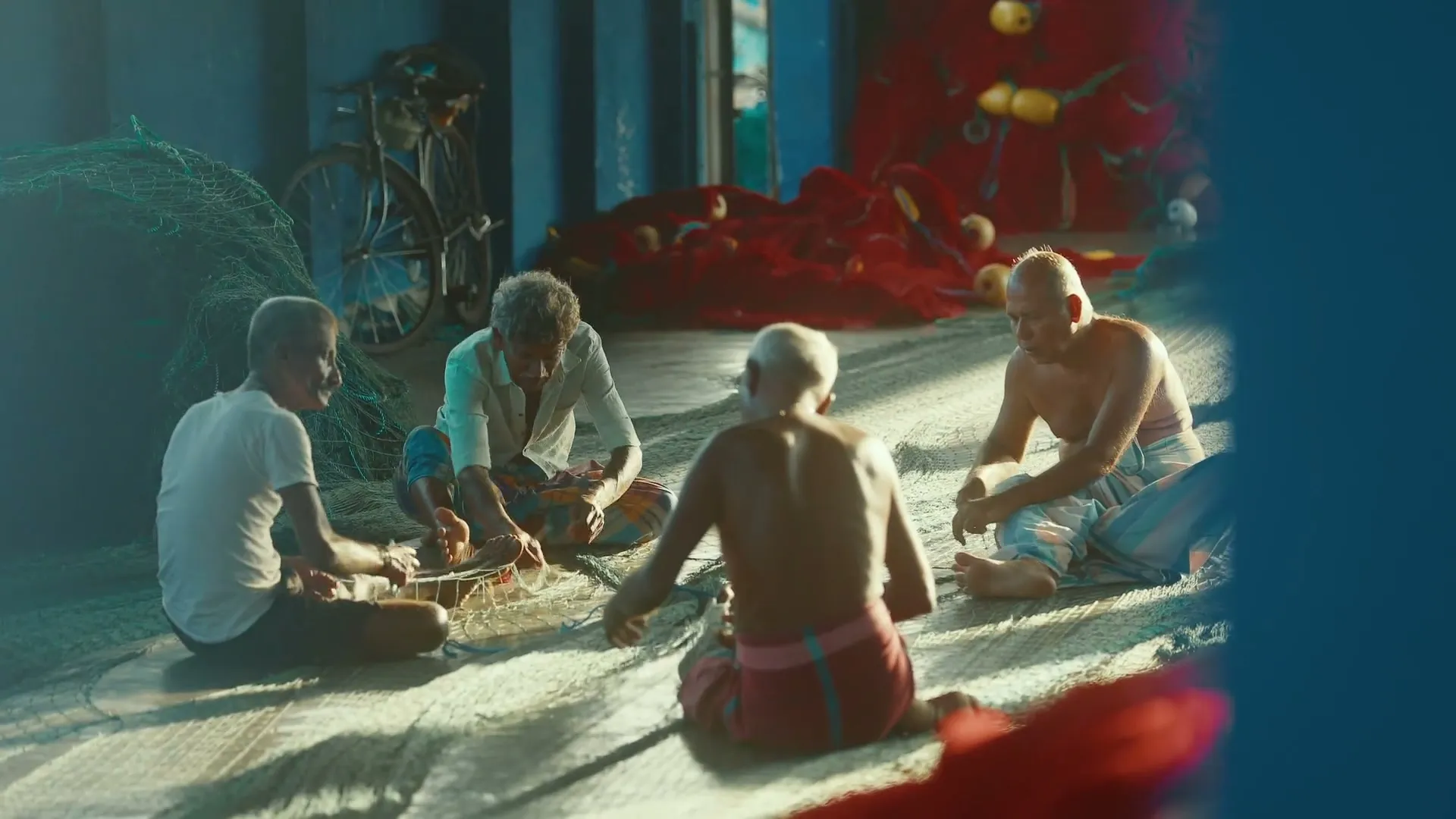 Four men sitting over the nets in the morning light
