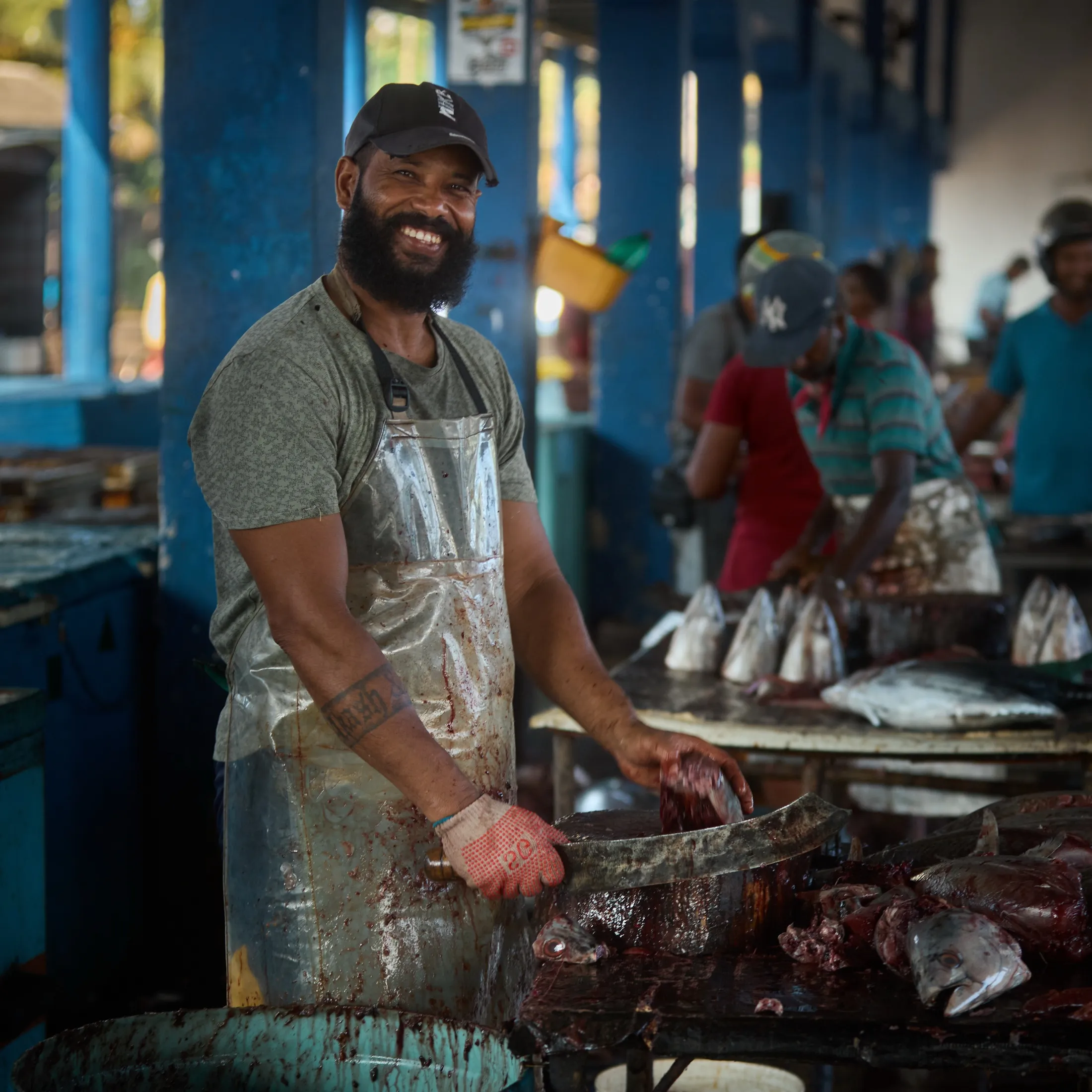 The cutter at his table, knife in hand, the market working behind him