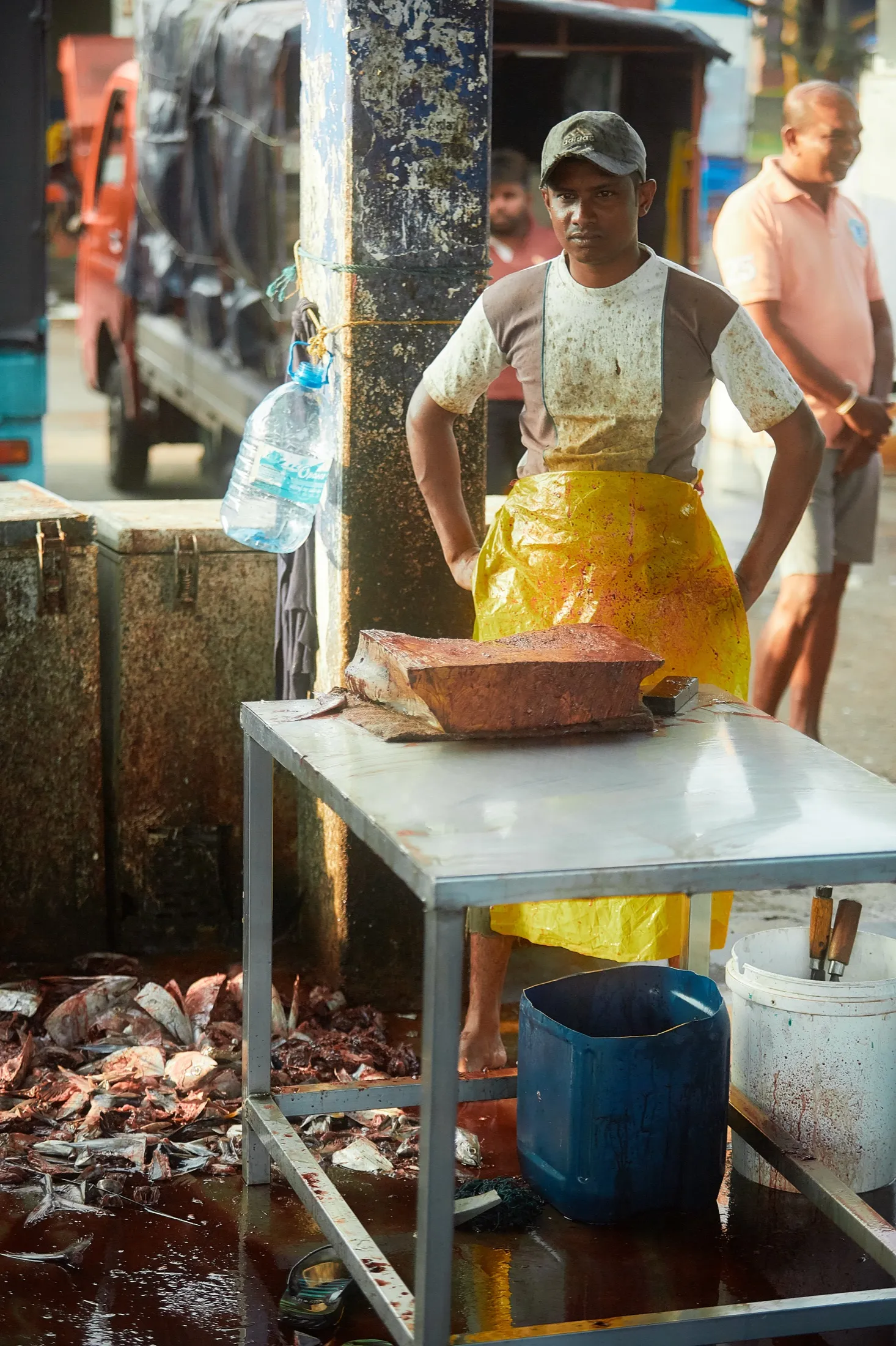 A cutter standing at his table in a yellow apron